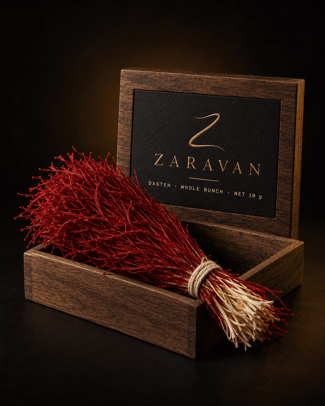 Hand-tied bunch of whole saffron threads, red tips and pale styles, in a wooden box.